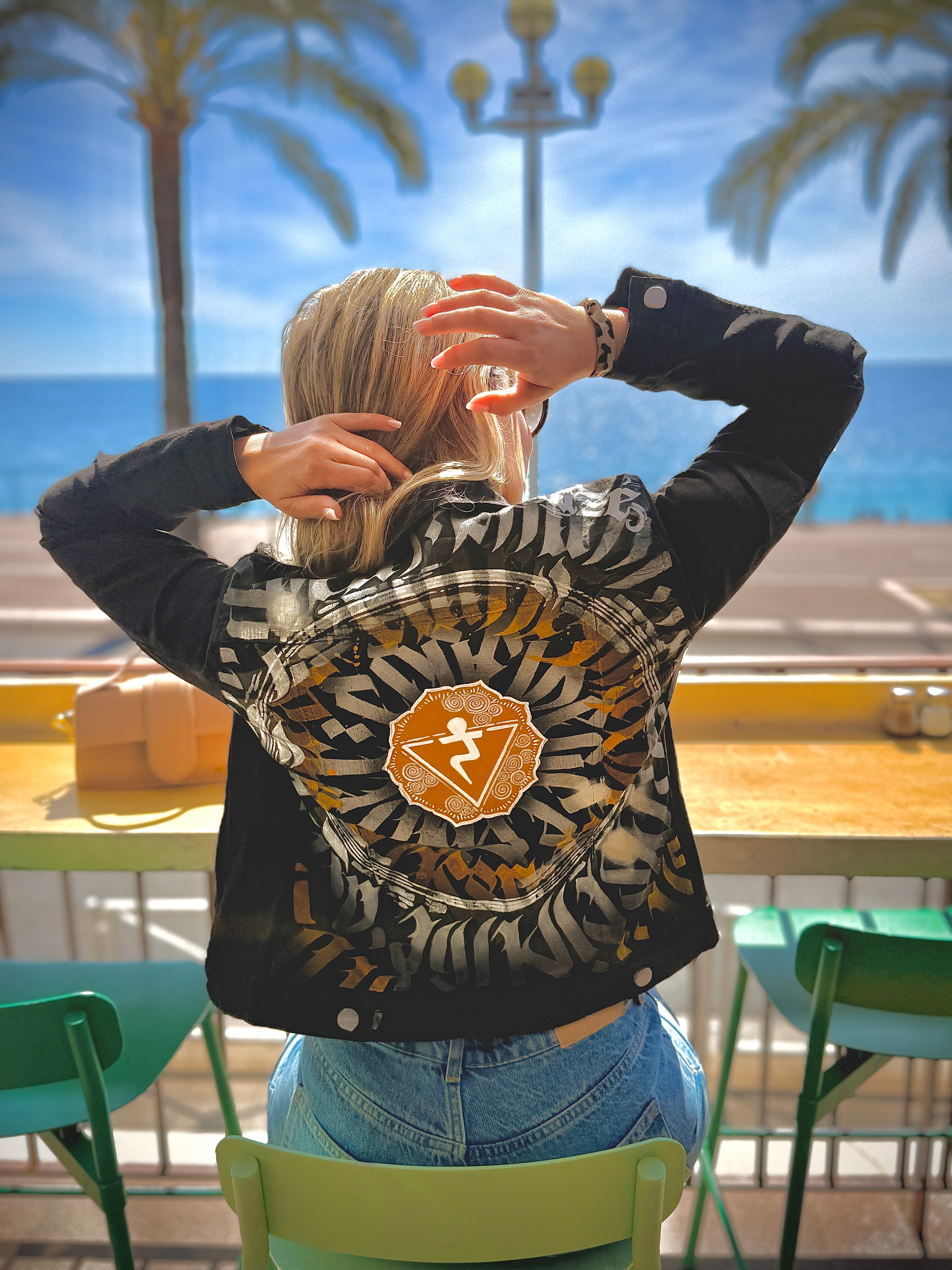 Veste en jean Calligraffiti Chamanisée avec motifs chakra solaire, déclinée par Razé Art Shop, vue de face.