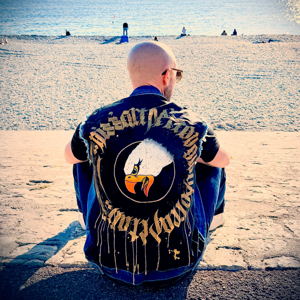 Hand-painted denim jacket by Niçois artist Razé, featuring calligraffiti inspired by Nice, spirituality and combat sports. Unique wearable artwork, some pieces ritually blessed by a shaman or priest.